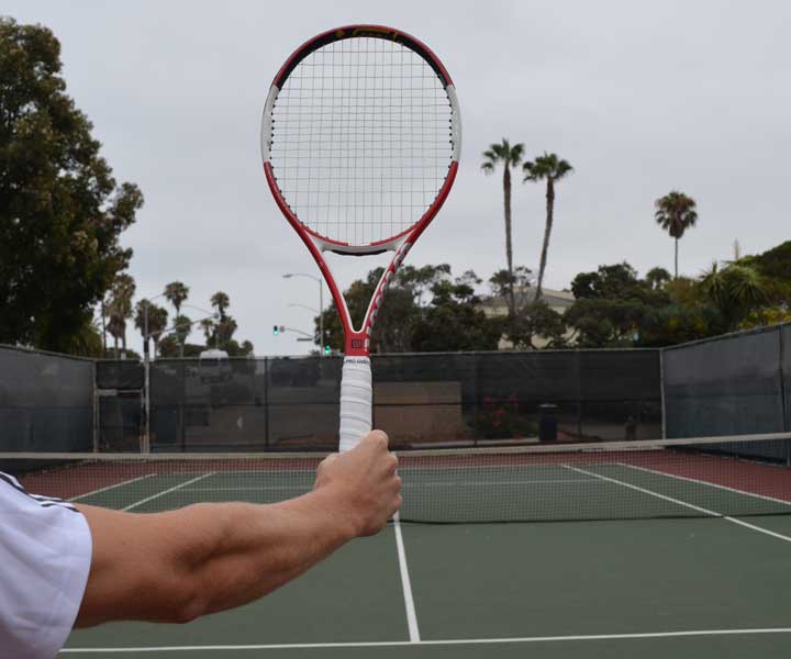 A photograph showing a tennis racquet being held out in front with the incorrect tennis serve grip.