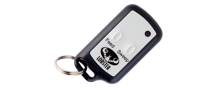 A black and grey keychain style remote for the Lobster Elite 2 that is has buttons for feed and sweep.