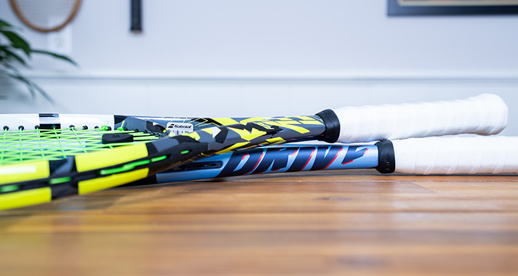 A Babolat Pure Aero and Babolat Pure Drive Resting Against Each Other