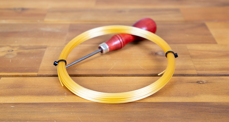 A Set of Luxilon 4G Resting on an Awl