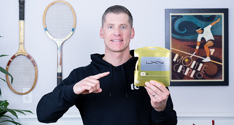 Jon Crim Holding a Pack of Luxilon 4G and Smiling