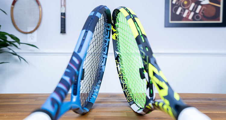 The Tip of a Babolat Pure Aero and Babolat Pure Drive Balanced Against Each Other